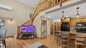 A spacious living area with a wooden staircase, a kitchen with wooden cabinets, and a dining area with wooden chairs. - 3 King Beds * Game Room * Heated Garage * Trails (Lead)