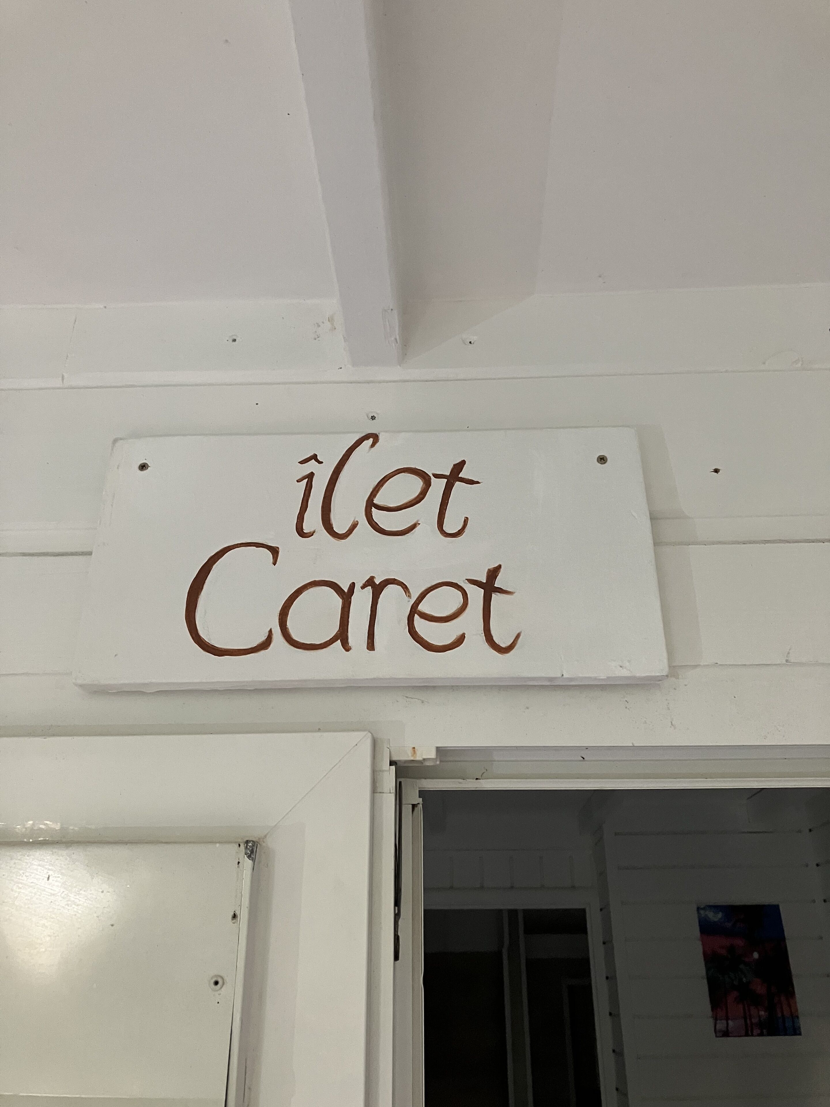 A sign with the text "ilet Caret" on a white wall.