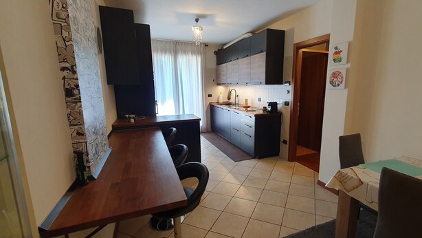 A compact kitchen with a dining area, a small table, and a chair.