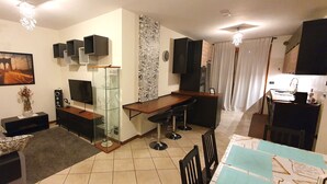 A modern living room with a sofa, a coffee table, a TV, and a glass cabinet.