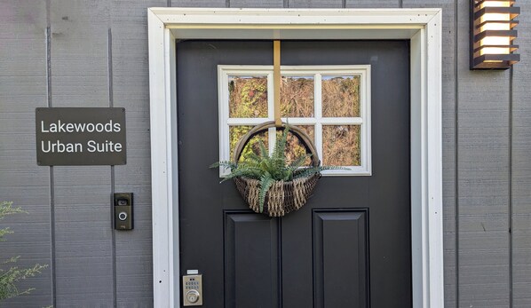 A black door with a window and a sign reading "Lakewoods Urban Suite".