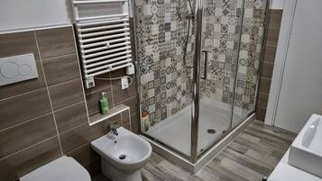 Een douche, een haardroger, een bidet, handdoeken