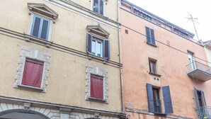 A multi-story building with arched doorways and windows with shutters. - Maison Chanel (Bologna)