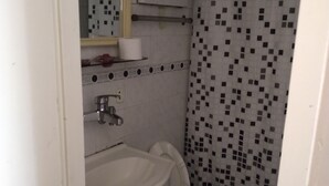 A small, compact bathroom with a toilet, sink, and mirror. - SUIPACHA INN HOTEL (Buenos Aires)