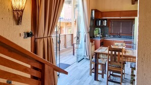 A spacious kitchen with wooden cabinets and a dining area with a table and chairs. - Valle Paradiso (Imbituba)