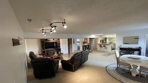 A spacious living room with a fireplace, a television, and a dining area with a table and chairs. - 3 bedroom loft (Wenatchee)