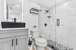 Regadera, secadora de cabello, toallas, papel de baño 