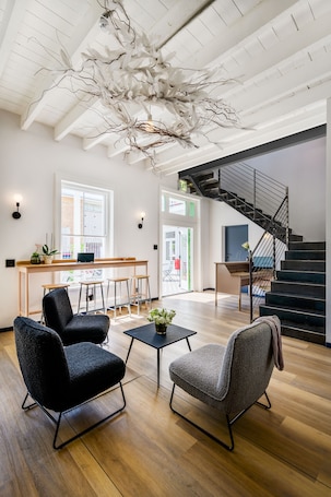 A spacious living area with a modern staircase, a dining area with a bar, and a view of the outside.