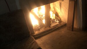 Una habitación con chimenea, un sofá y un tapete estampado.