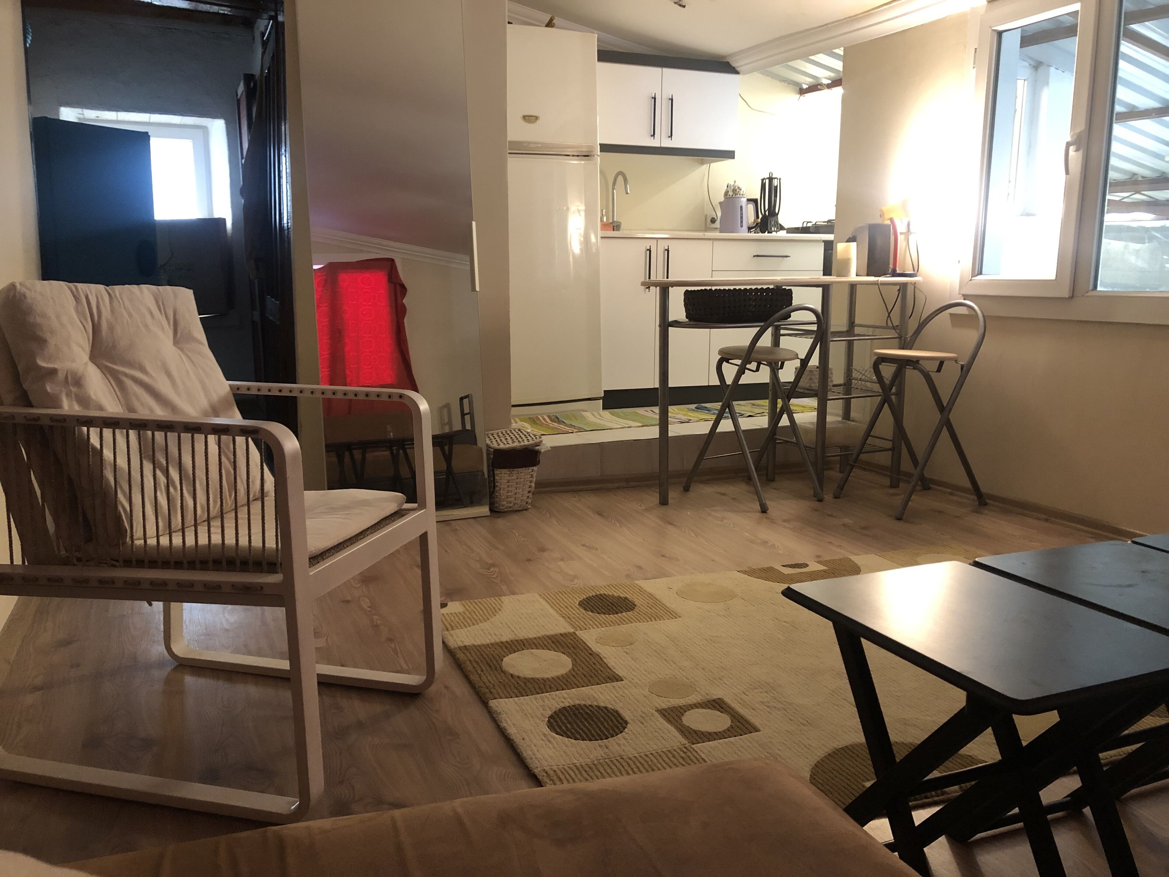 Un espace de vie compact comprenant un coin cuisine, un coin repas et un espace détente avec une chaise et une table.