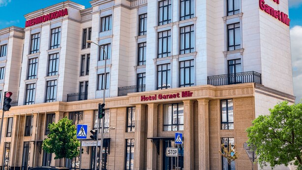 A hotel building with multiple floors, large windows, and a prominent "HOTEL" sign. - Garnet Mir Hotel (Tashkent)