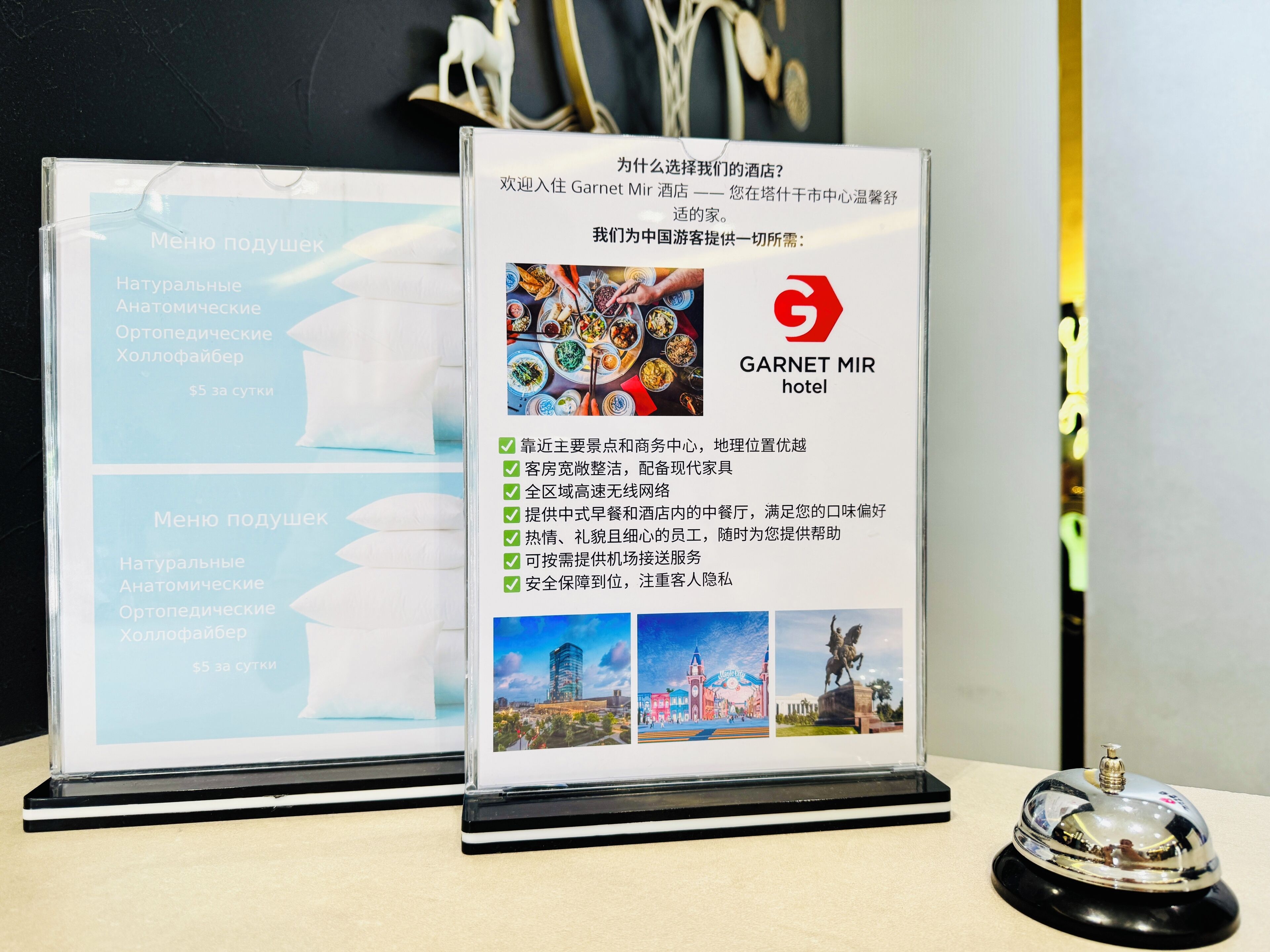 A framed informational display about Garnet Mir hotel, highlighting its proximity to the city center, modern amenities, and a clean, well-maintained environment.