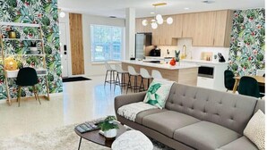 A modern living room with a sofa, coffee table, and a bookshelf. - Peaceful & Private Waterfront Retreat w/Heated Pool near Beach & Downtown Stuart (Stuart)