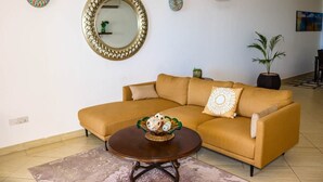 A living room with a sofa, coffee table, and decorative items.