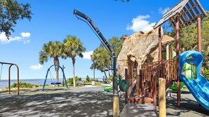 A playground with swings, a slide, and a climbing structure. - Luxury place - 23019 in Port Charlotte , one block to the Bayfront Park/Harbor (Port Charlotte)