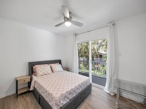 A bedroom with a bed, nightstand, and a ceiling fan. - Luxury place - 23019 in Port Charlotte , one block to the Bayfront Park/Harbor (Port Charlotte)