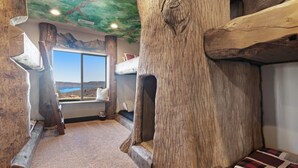 Une pièce dotée d’une grande fenêtre, de poutres en bois et offrant une vue sur l’extérieur.