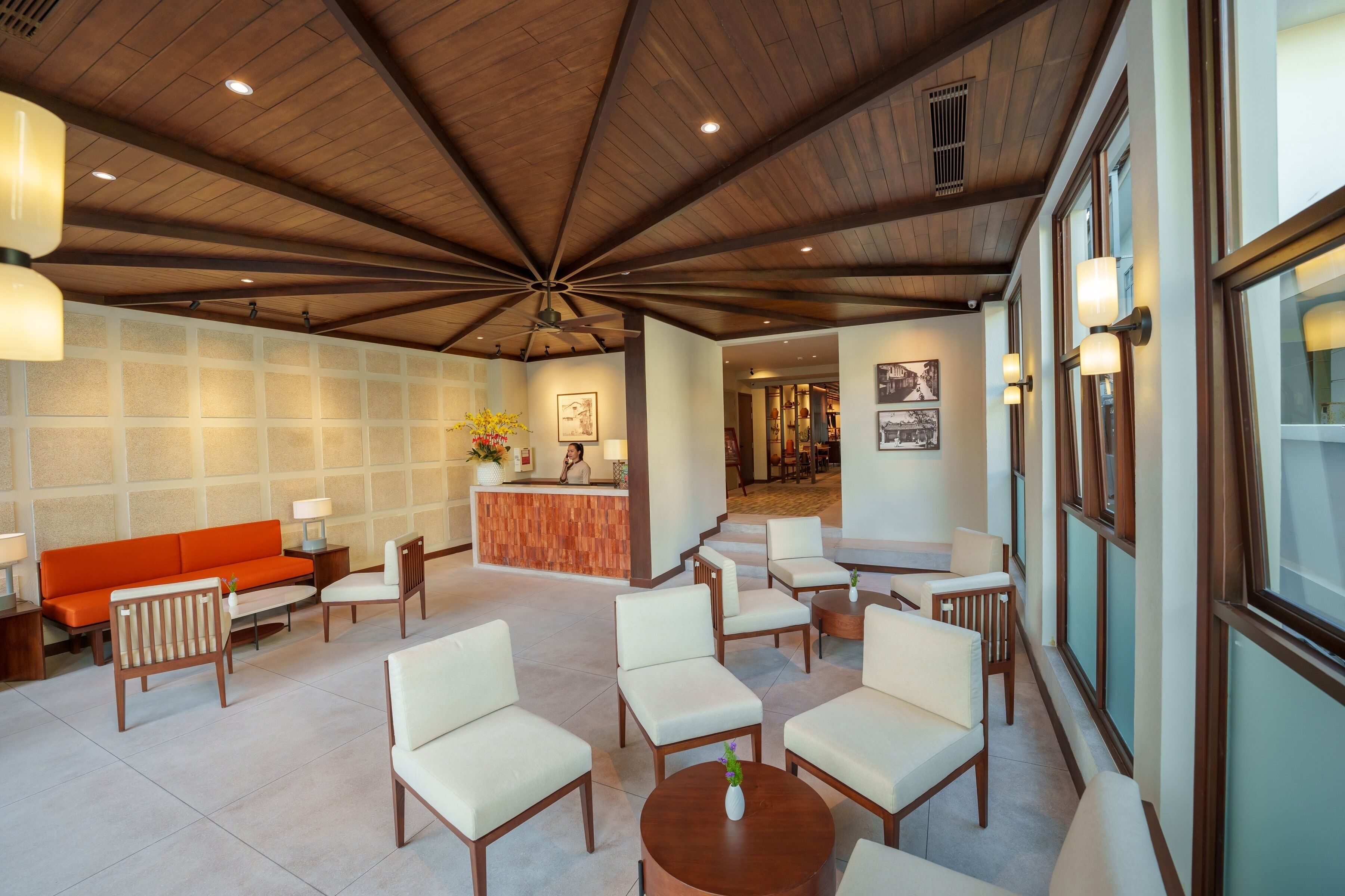A lobby with a wooden ceiling, a reception desk, and seating areas.