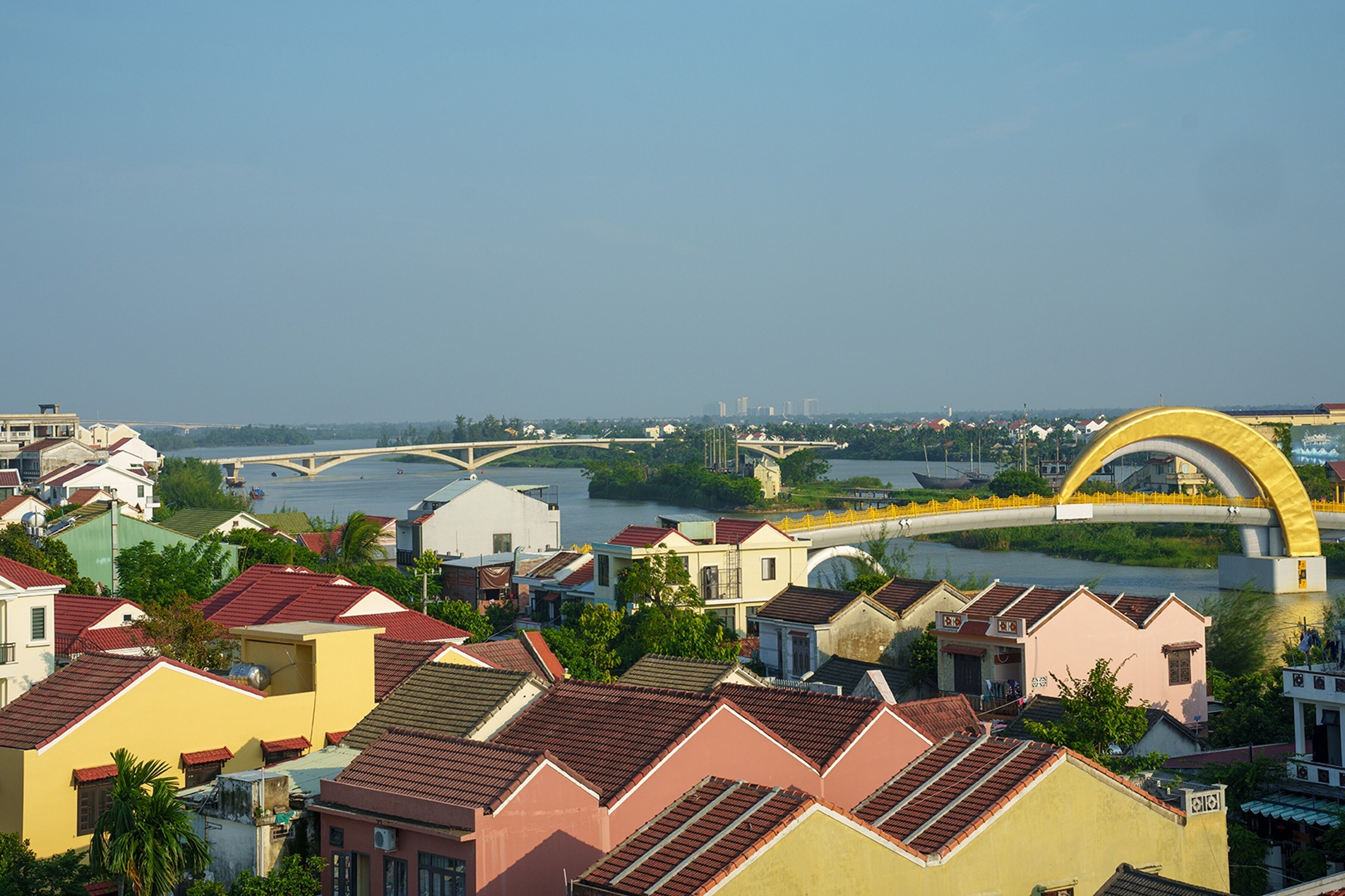 A residential area with houses, a bridge, and a river.