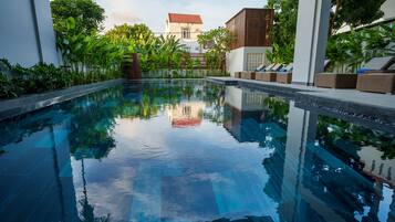 Una piscina al aire libre, sombrillas
