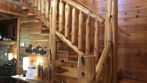 A wooden staircase in a rustic interior with a 'Great Cabin' sign above. - Alpine Adventure - Mountian home close to attractions! (Pigeon Forge)