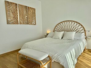 A bedroom with a bed, a bench, a nightstand, and wall art. - ALTHAIA HILLS- Beautiful townhouse with panoramic terrace and sea and mountain views (Altea)