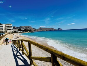 A beach with a wooden walkway, clear blue water, and rocky hills in the background. - ALTHAIA HILLS - Beautiful townhouse with a panoramic terrace and views of the sea and mountains (Altea)