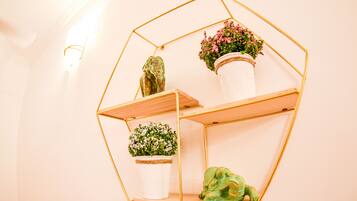 A hexagonal metal shelf with three potted plants.