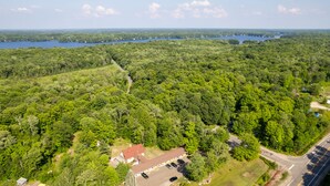 An aerial view of a forested area with a small building and a parking lot. - The Dudley Inn (Muskoka Lakes)