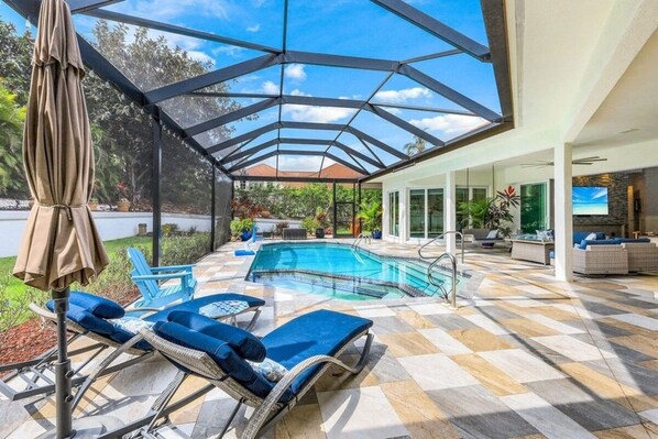 Relax by the pool surrounded by a checkered floor and lounge chairs with comfortable cushions.