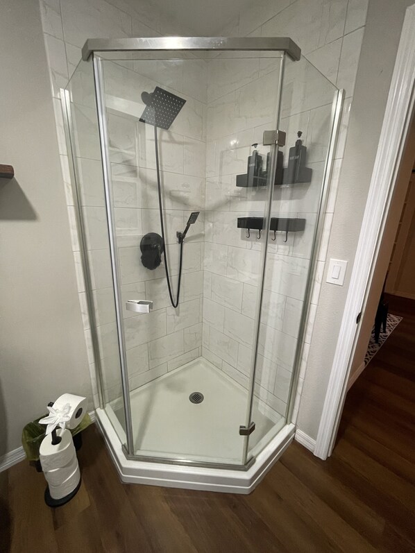 A glass-enclosed shower with a handheld showerhead and a wall-mounted faucet. - Riverside Chic 180° water views - fish/boat/kayak - pet friendly (Inverness)