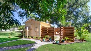 A small wooden structure with an air conditioning unit, surrounded by a wooden fence and potted plants. - Private Surf Shack Less Than 5 Minutes to Indian Rocks Beach
Bikes Included! (Largo)
