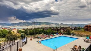 Une piscine avec des chaises longues et une vue sur les montagnes en arrière-plan.