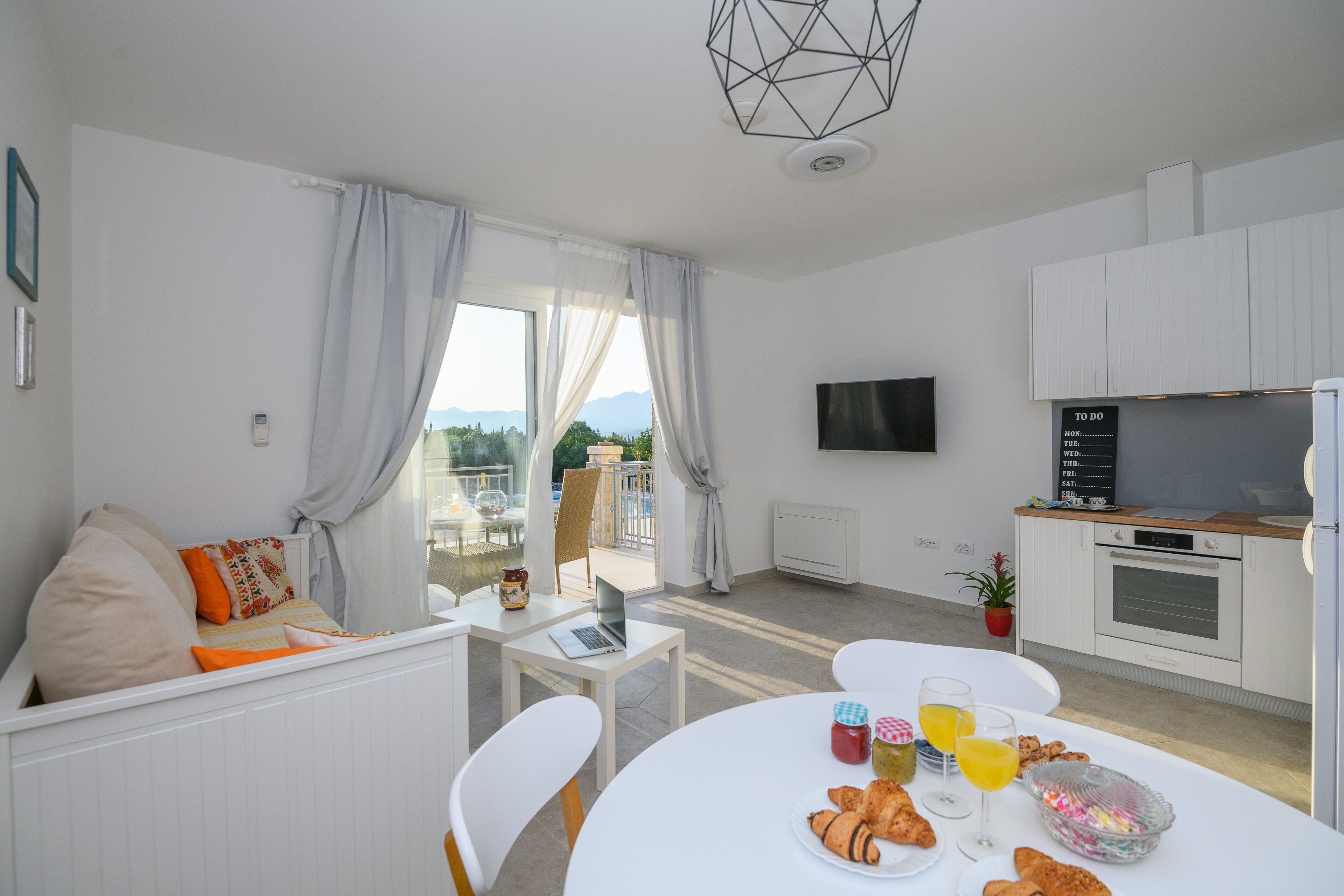 Een moderne keuken met een eethoek, een televisie en uitzicht op de omgeving.