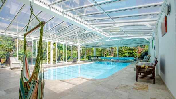 A covered swimming pool with lounge chairs and a hammock. - La Ribambelle - Saint Hilaire Sous Romilly (SAINT HILAIRE SOUS ROMILLY)