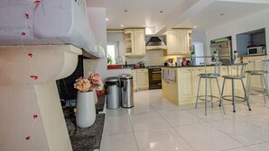 A modern kitchen with a central island, stainless steel appliances, and a bar area with stools. - La Ribambelle - Saint Hilaire Sous Romilly (SAINT HILAIRE SOUS ROMILLY)