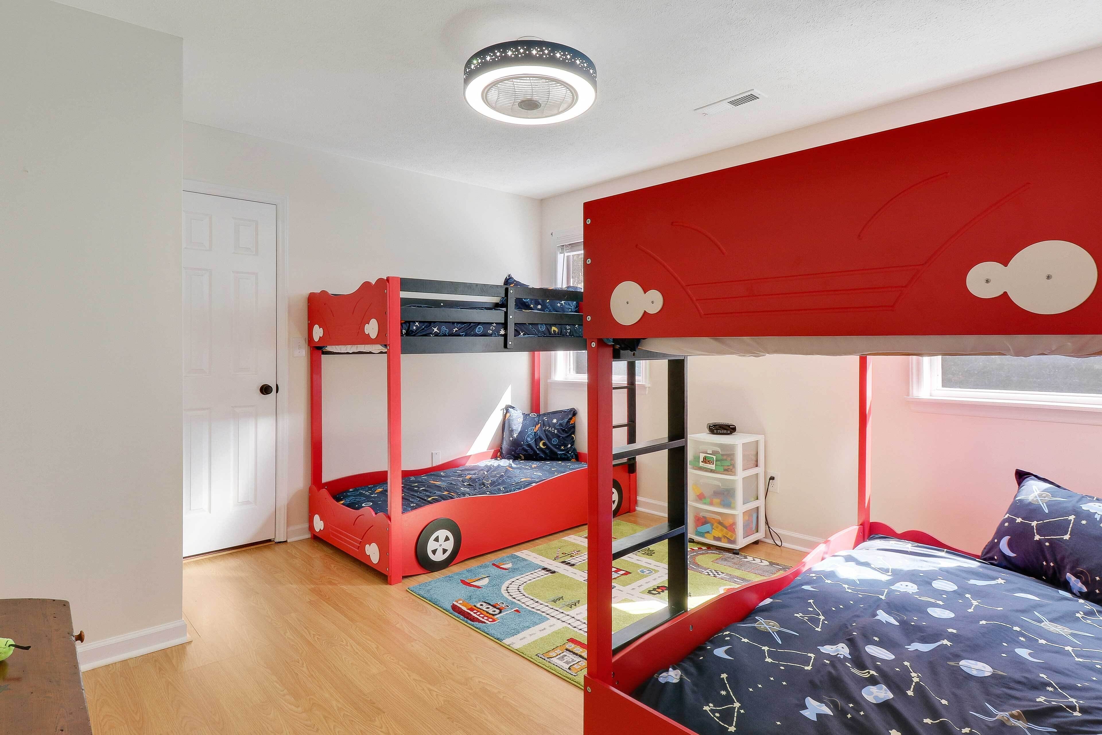 A child's bedroom with bunk beds, a window, and a ceiling fan.