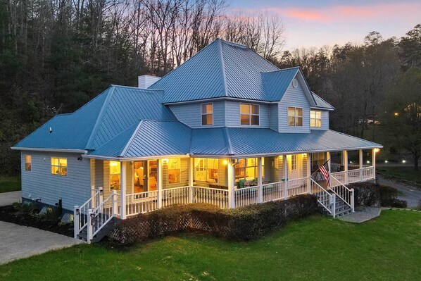 A large, two-story house with a wrap-around porch and a steeply pitched roof. - Spacious Murphy Home w/ Game Room + Fire Pit! (Murphy)