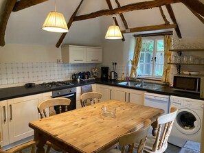 Een magnetron, een oven, een vaatwasser, kookgerei, borden en bestek