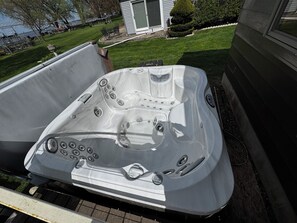 Un bain à remous doté de plusieurs jets, d’un panneau de commande et d’un drain.