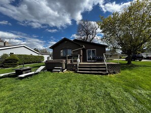 Une maison de plain-pied avec un patio, un jacuzzi et une petite terrasse.