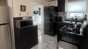 Una cucina dotata di frigorifero, microonde, fornello e lavatrice.