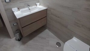 A bathroom with a white sink, a mirror, and a toilet. - Elegant standard room in Riccia (Molise)