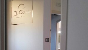 A door with a sign that reads "Il Ricco" and a small logo above it. - Elegant standard room in Riccia (Molise)