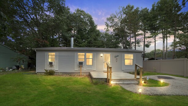 A single-story house with a front porch, a chimney, and a small front yard. - Quaint Cabin: Beach Days & Bonfire Nights – The Ultimate Summer Escape! No Central A/C (Oscoda)