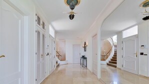 A spacious hallway with a marble floor, white doors, and a staircase leading to another level. - Colina del Mar, un Magnífico Jardín con Piscina y Maravillosas Vistas (Benalmádena)