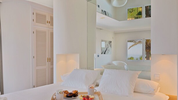 A hotel room with a bed, a tray of breakfast, a balcony with plants, and a view of the sea. - Colina del Mar, un Magnífico Jardín con Piscina y Maravillosas Vistas (Benalmádena)