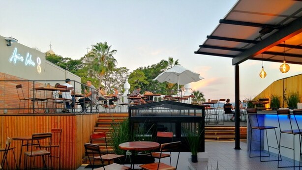 An outdoor patio area with tables and chairs, a pool, and a bar area. - C. Santos Degollado 34 (Colima)