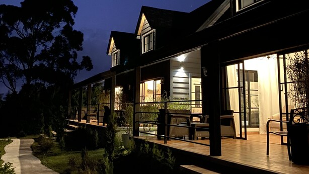 A modern house with a covered patio and a concrete pathway leading to the entrance. - Risco de Hugo (Boquete)