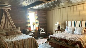 Une chambre chaleureuse avec deux lits, un plafond en bois et une décoration rustique.